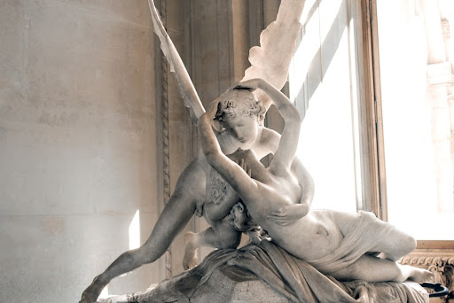 an angel holding a woman sculpture