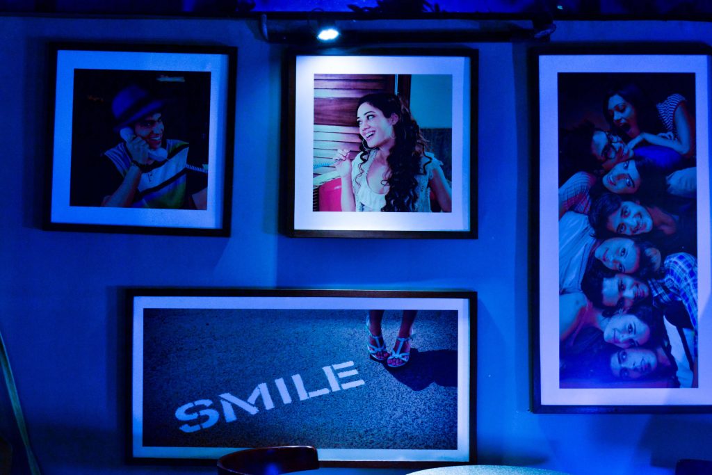 Blue light shining gallery wall art frames with pictures of people